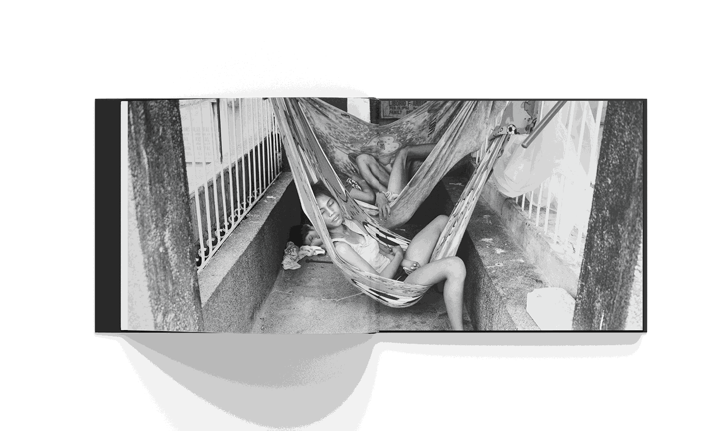 Black and white photo of two people resting in hammocks in a cemetery in Manila from Brad Mirman's Cemetery City book