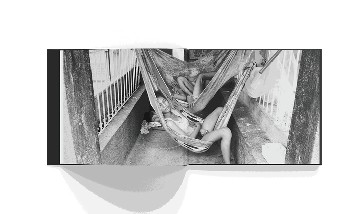 Black and white photo of two people resting in hammocks in a cemetery in Manila from Brad Mirman's Cemetery City book