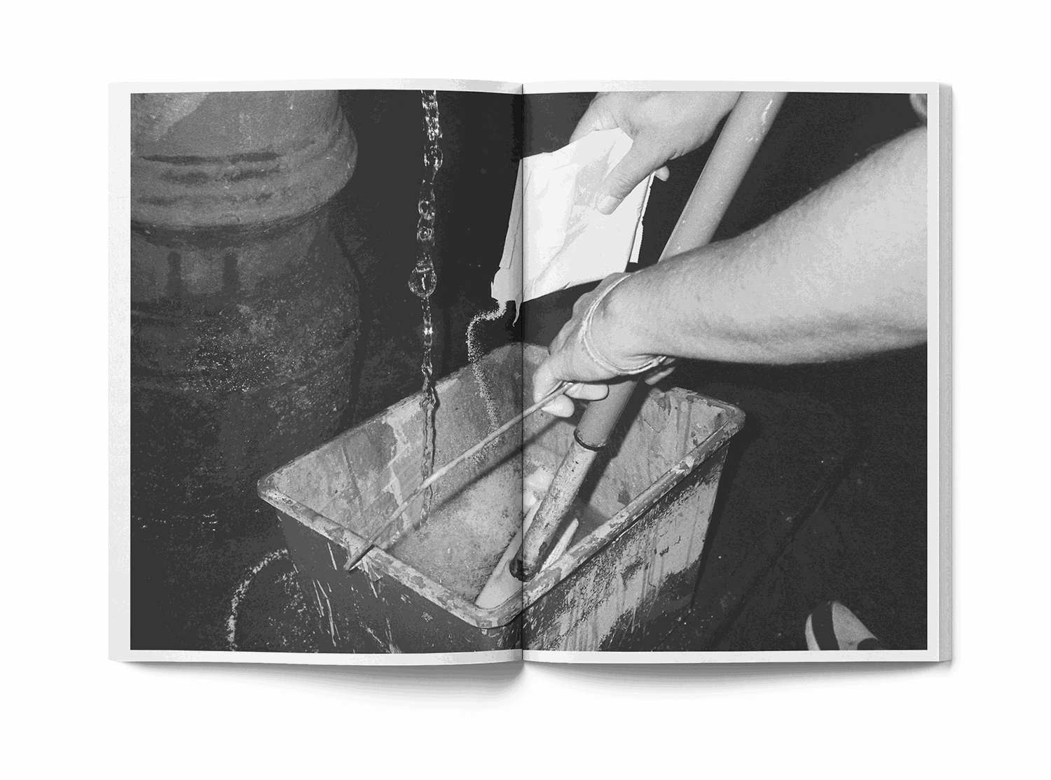 Open book showing street art mural with skull and Colosseum, man in red shirt painting wall, Lucamaleonte Colla 00139 book photo