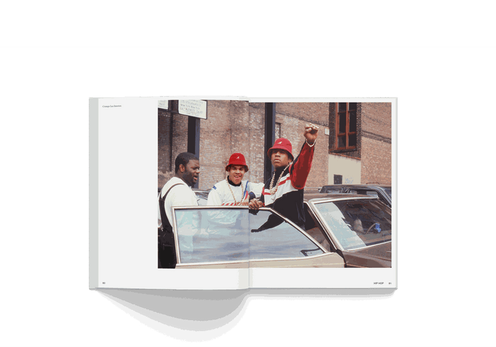 Open book showing a colorful street photo of three men by a car, from Janette Beckman's "Rebels, From Punk to Dior" photography monograph