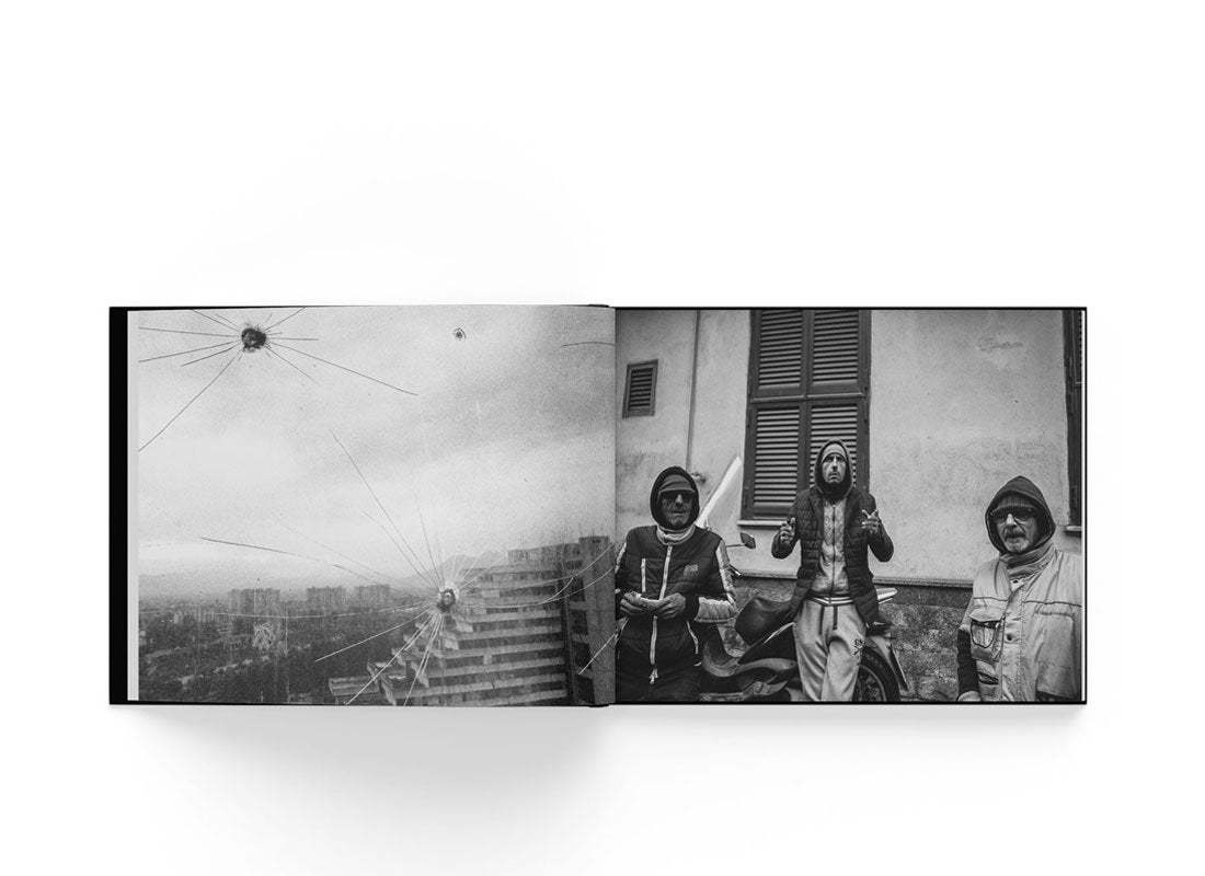 Open black and white photo book Neapolis by Boogie showing urban street scene with three men in hoodies.