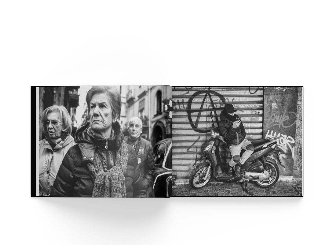 Open book showing black and white street photography of elderly people and a person on a scooter against graffiti wall, from Boogie's Neapolis photo book.