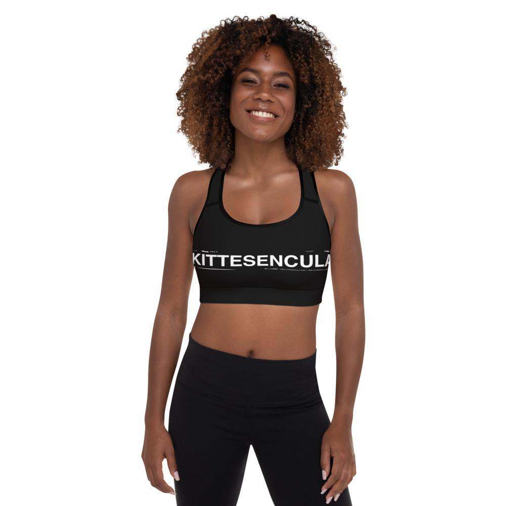 Woman wearing black Kittesencula Sport Bra with racerback and logo print, paired with black leggings
