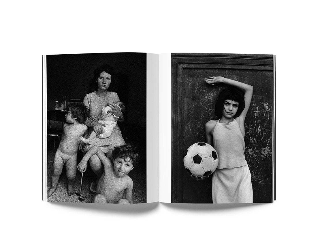 Open book showing black and white documentary photographs by Letizia Battaglia featuring children and a woman with a soccer ball