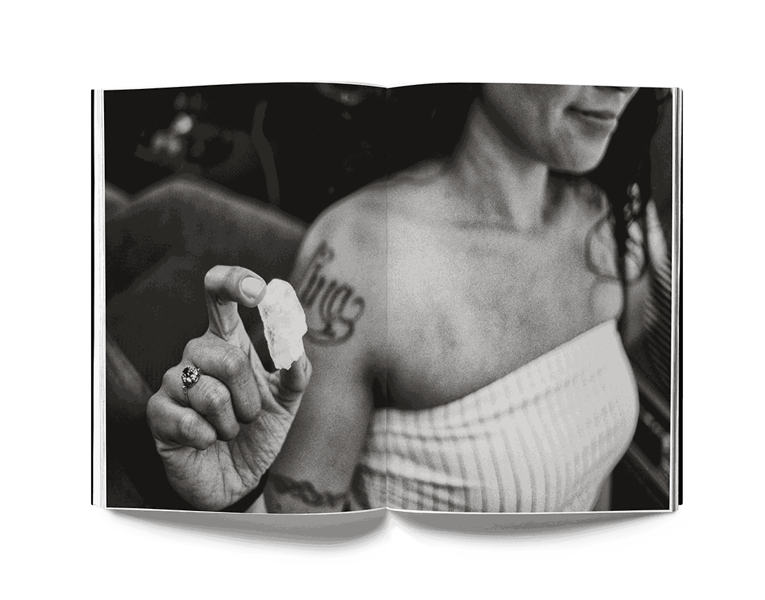 Black and white photograph by Estevan Oriol showing a tattooed woman holding a small object, featured in the book This is Los Angeles.