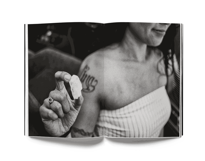 Black and white photograph by Estevan Oriol showing a tattooed woman holding a small object, featured in the book This is Los Angeles.