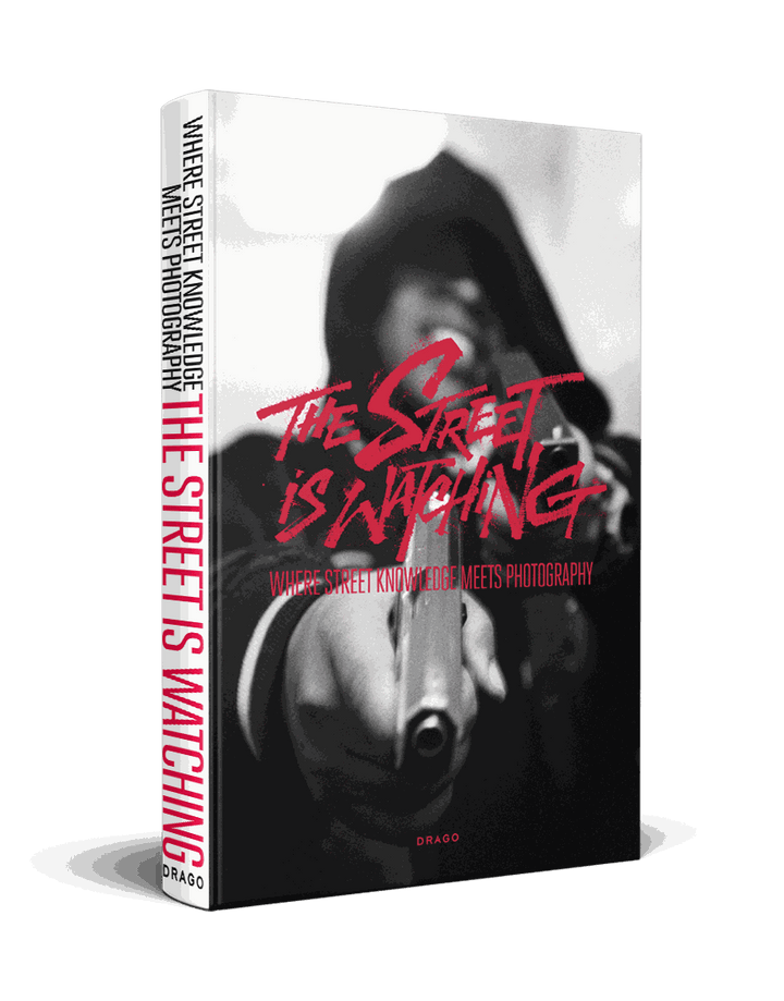The Street is Watching street photography book cover with blurred black and white image and red title text