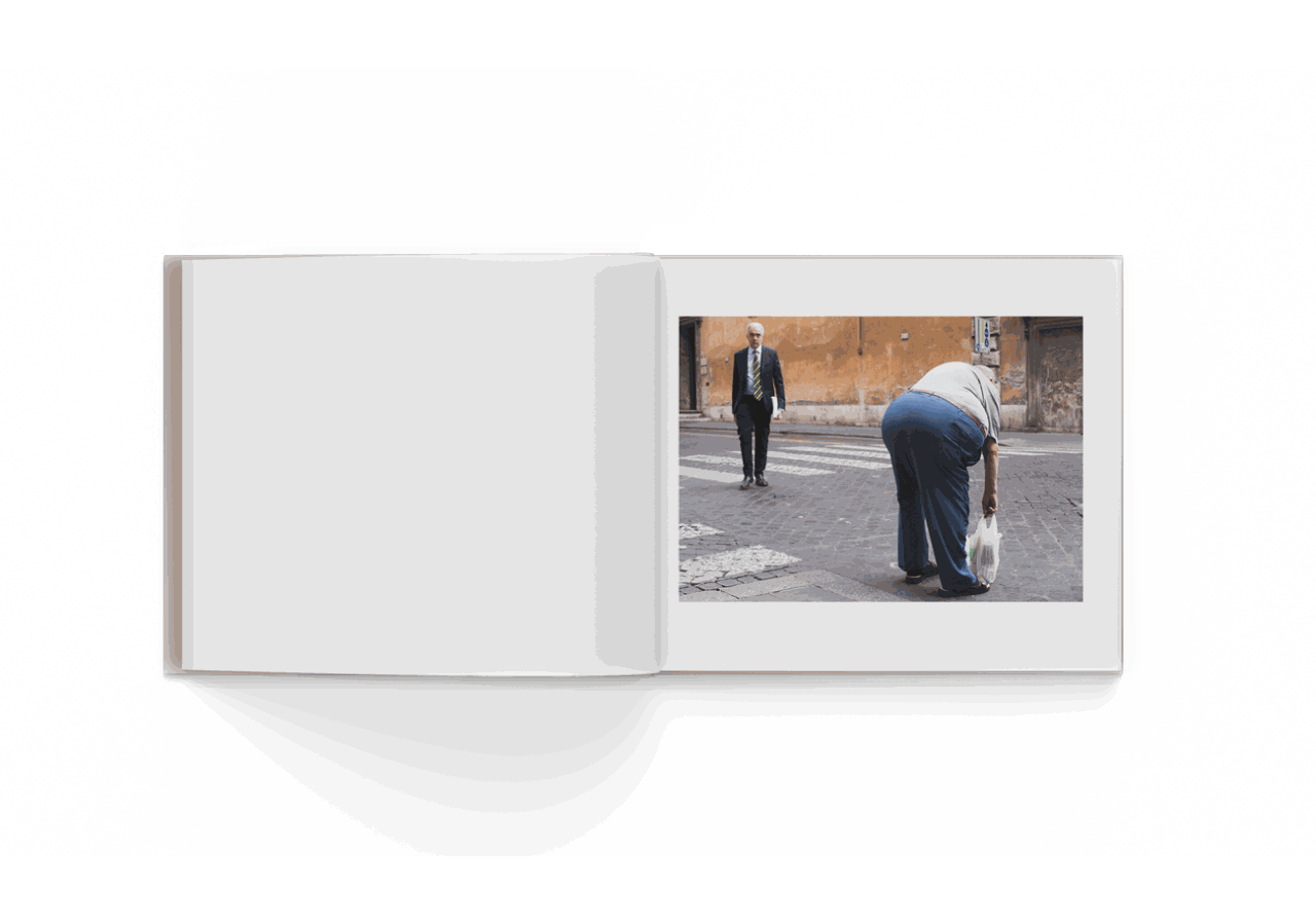 Open photo book showing street photography by Mohamed Keita featuring two people on a city sidewalk in Rome