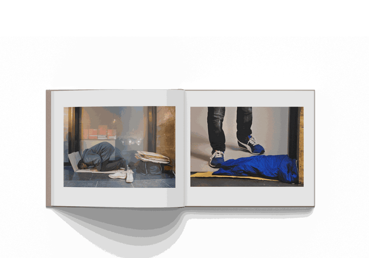 Open book showcasing two poignant photographs by Mohamed Keita from Rome 10/20 project, highlighting urban and human elements.