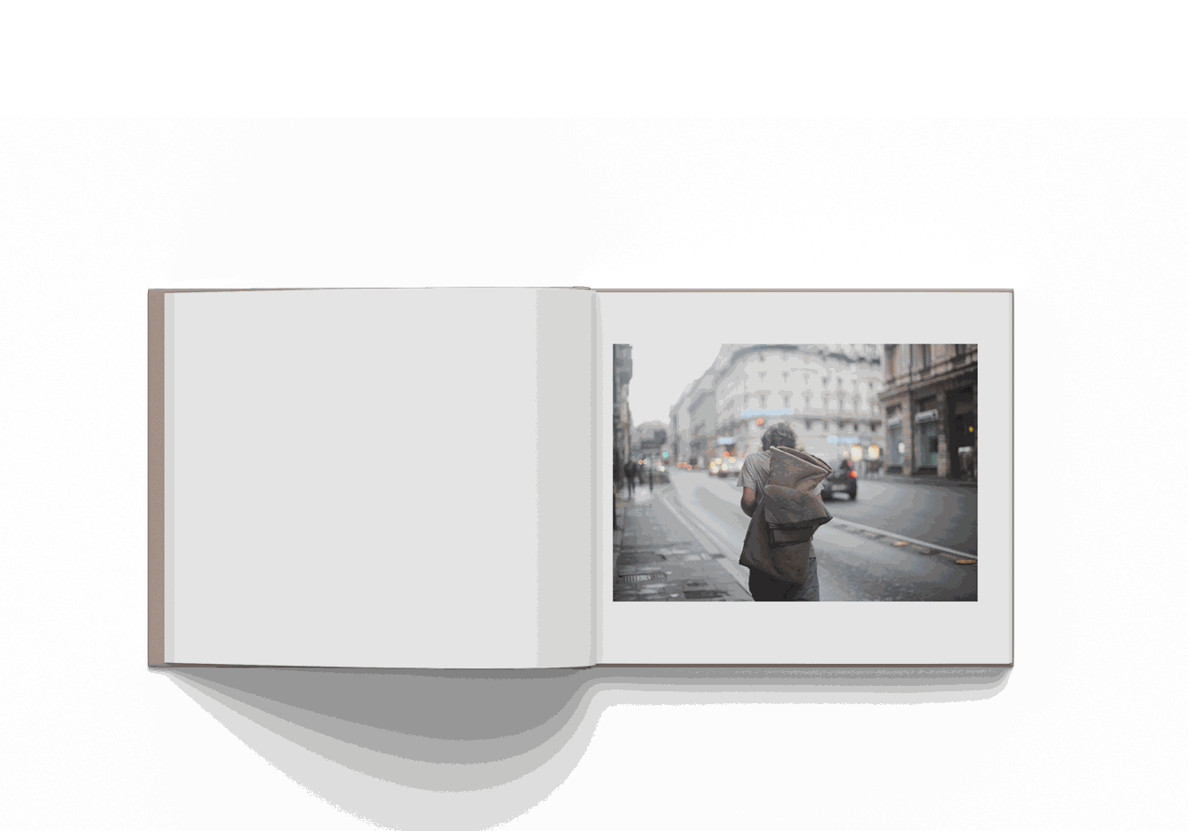 Open photography book featuring a street photo of a person walking in Rome by Mohamed Keita