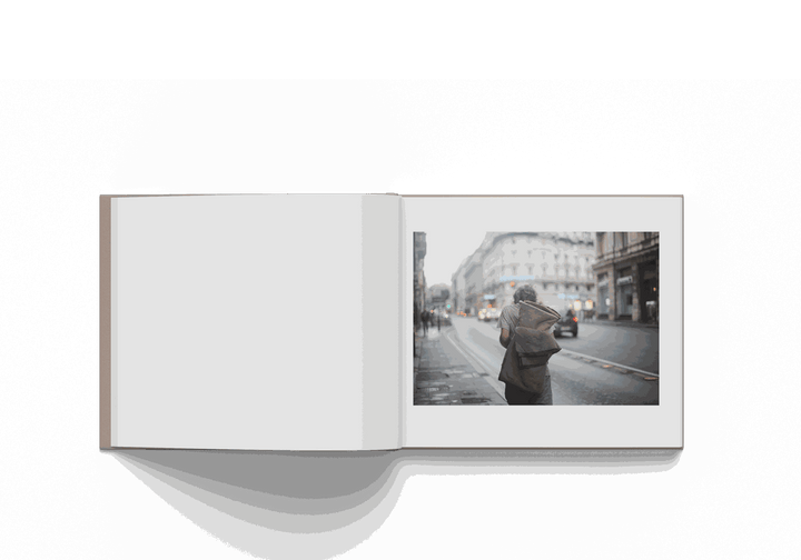 Open photography book featuring a street photo of a person walking in Rome by Mohamed Keita