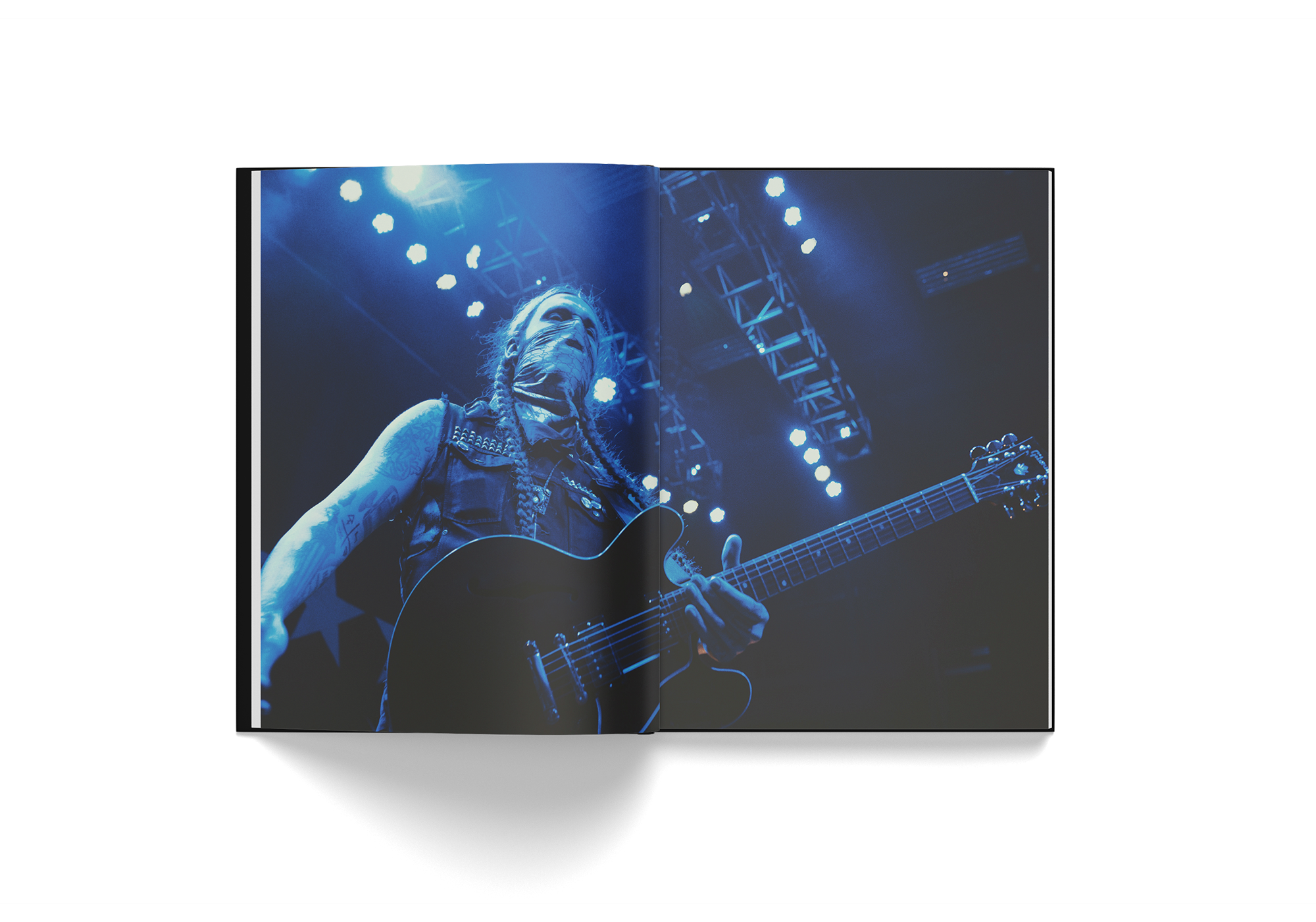 Open book showing a full-page photo of Yelawolf playing guitar on stage under blue lights from Edward Crowe's Yelawolf 51/50 hardcover book.